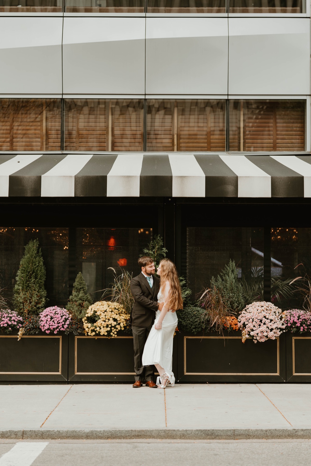 Bride and groom sharing a kiss in front of a gazebo with string lights